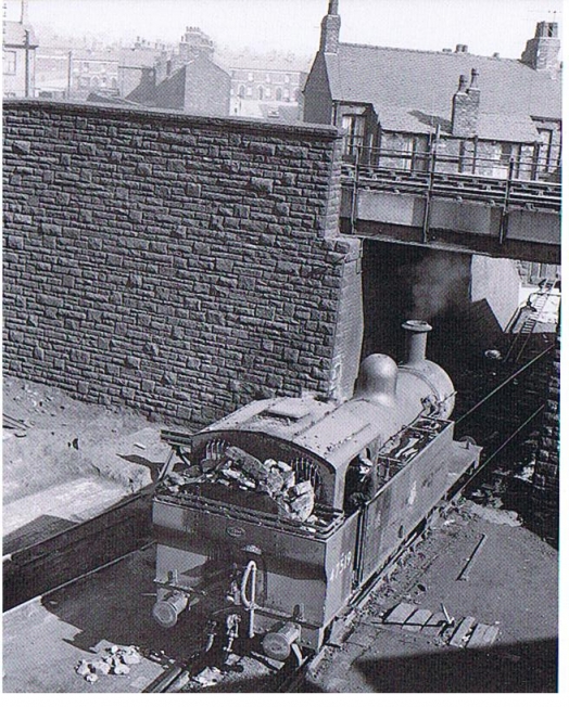 Tank locomotive passing under a bridge